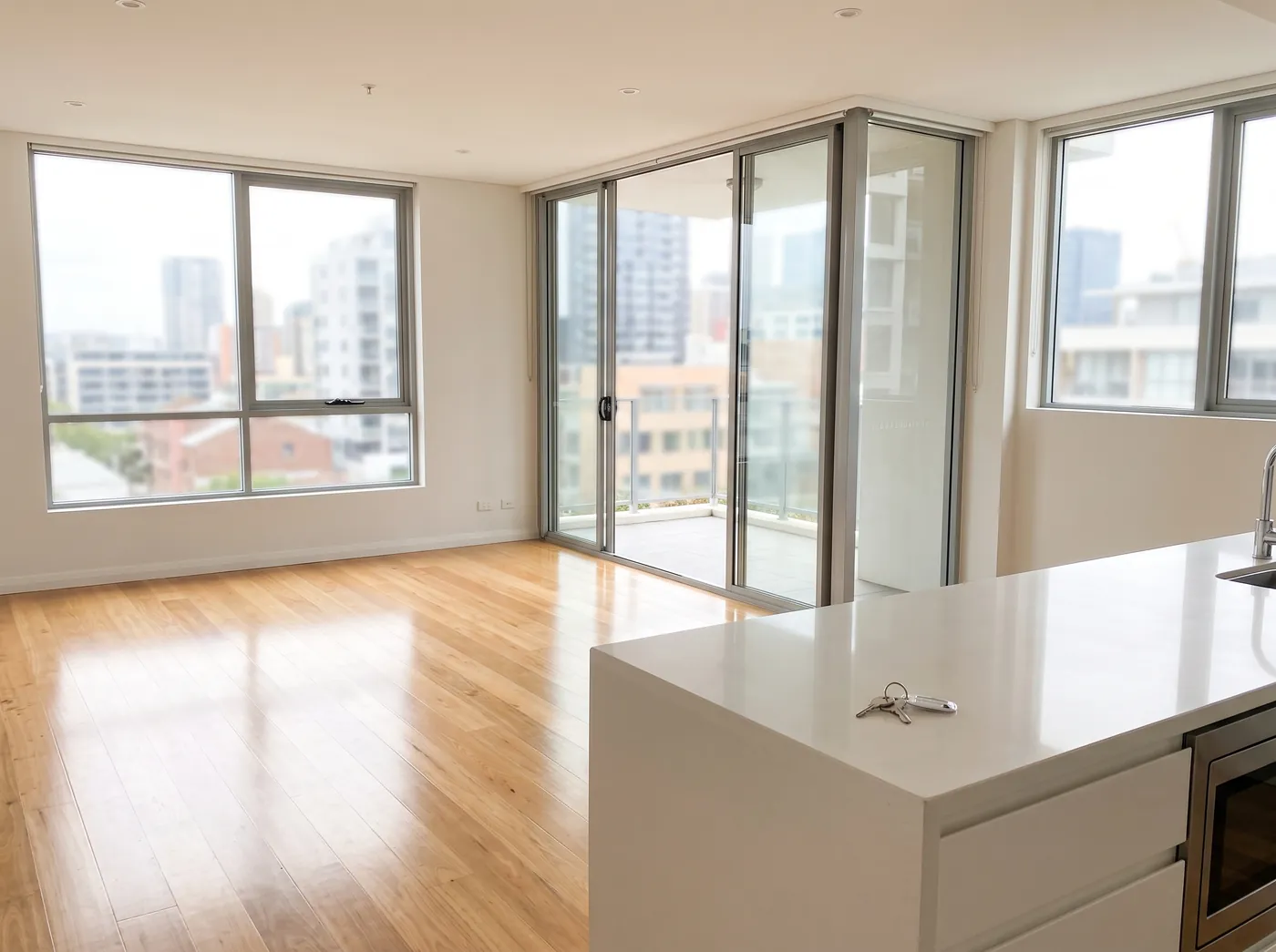 An empty, spotless apartment with keys left on the kitchen bench